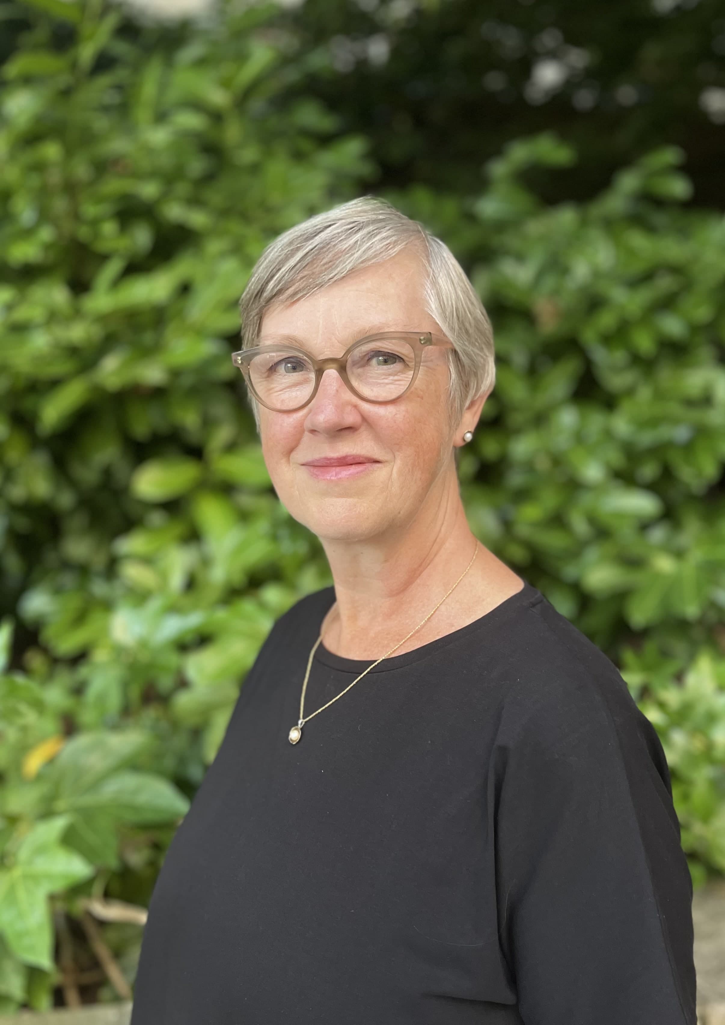 Head shot of Judith Squires against a backdrop of greenery