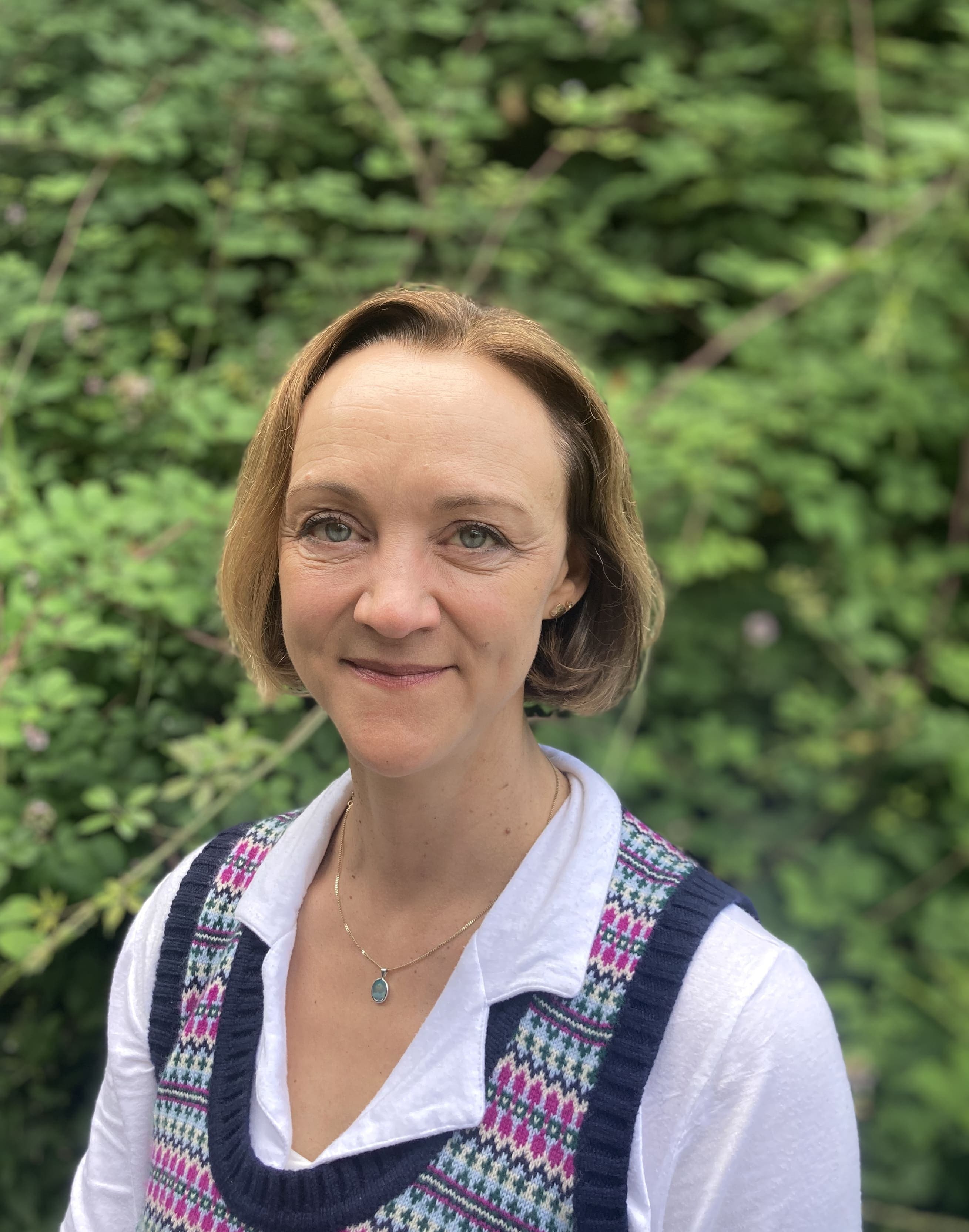 Head shot of Sarah Fuller against a backdrop of greenery