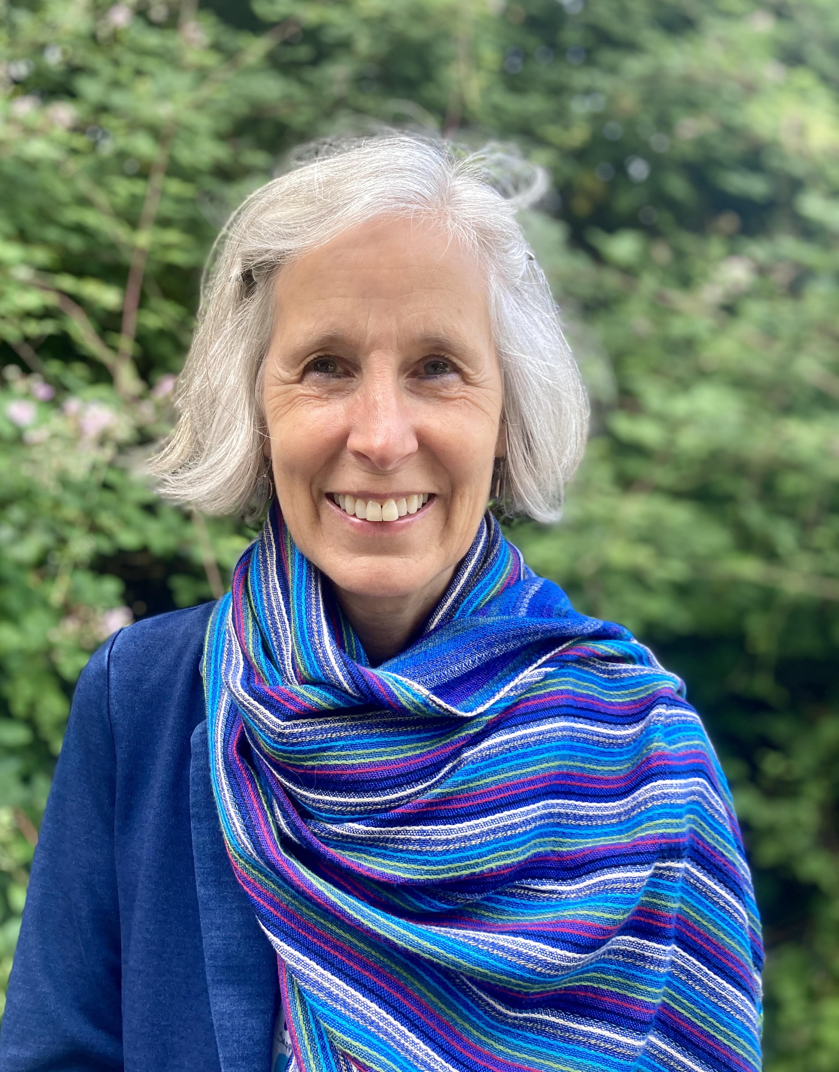Head shot of Jane Smart against a backdrop of greenery